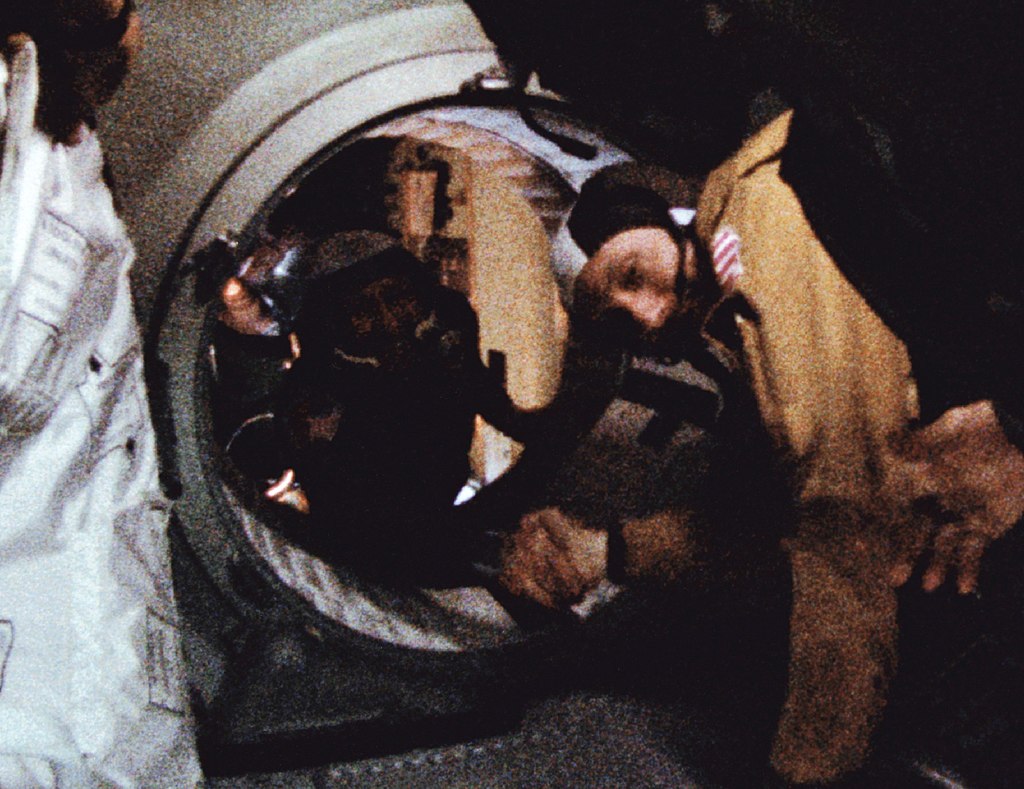 American astronaut and Soviet cosmonaut shake hands between Apollo and Soyuz.